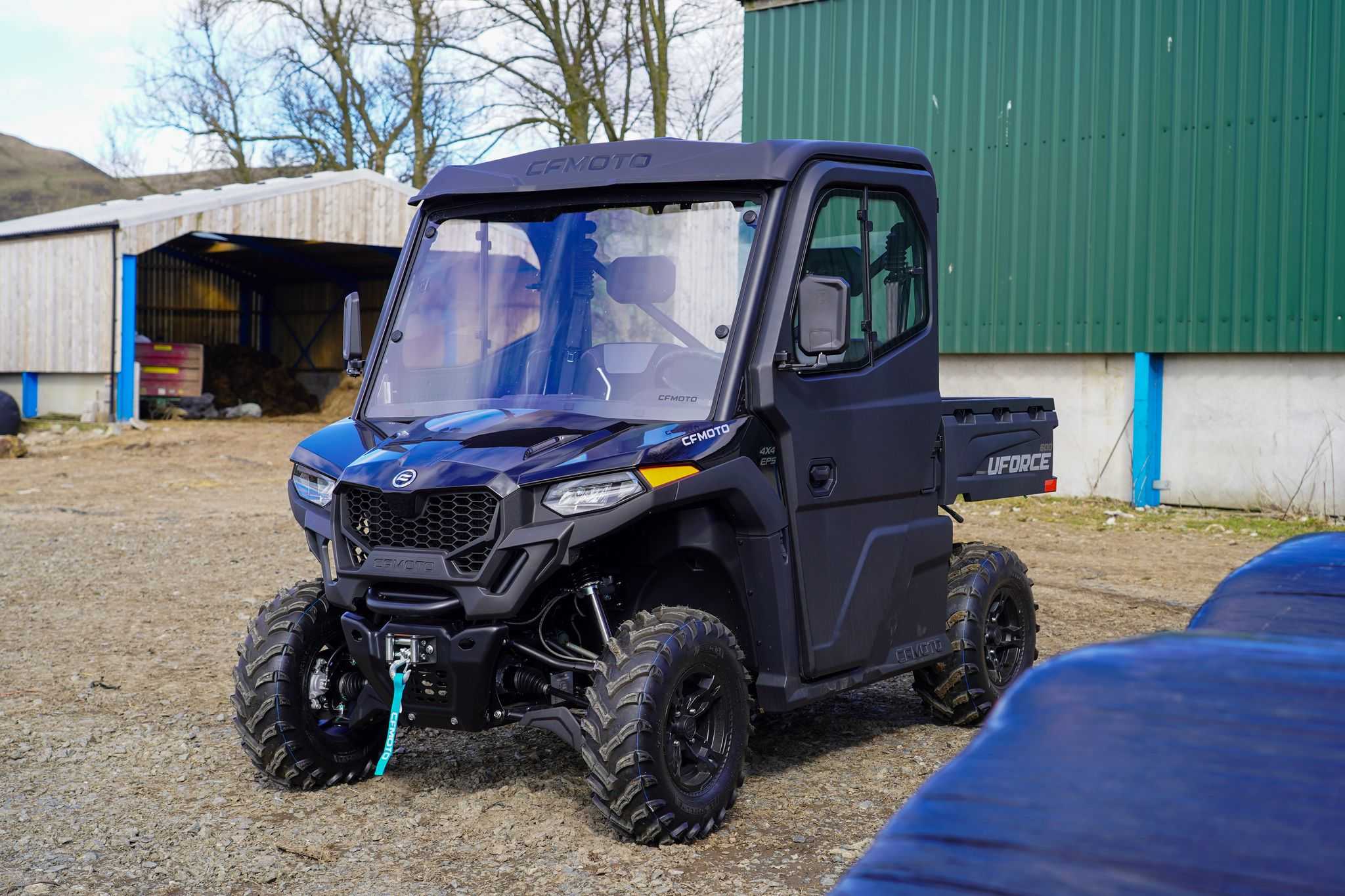 CFMOTO off road UTV utility vehicle with enclosed cab on gravel blue