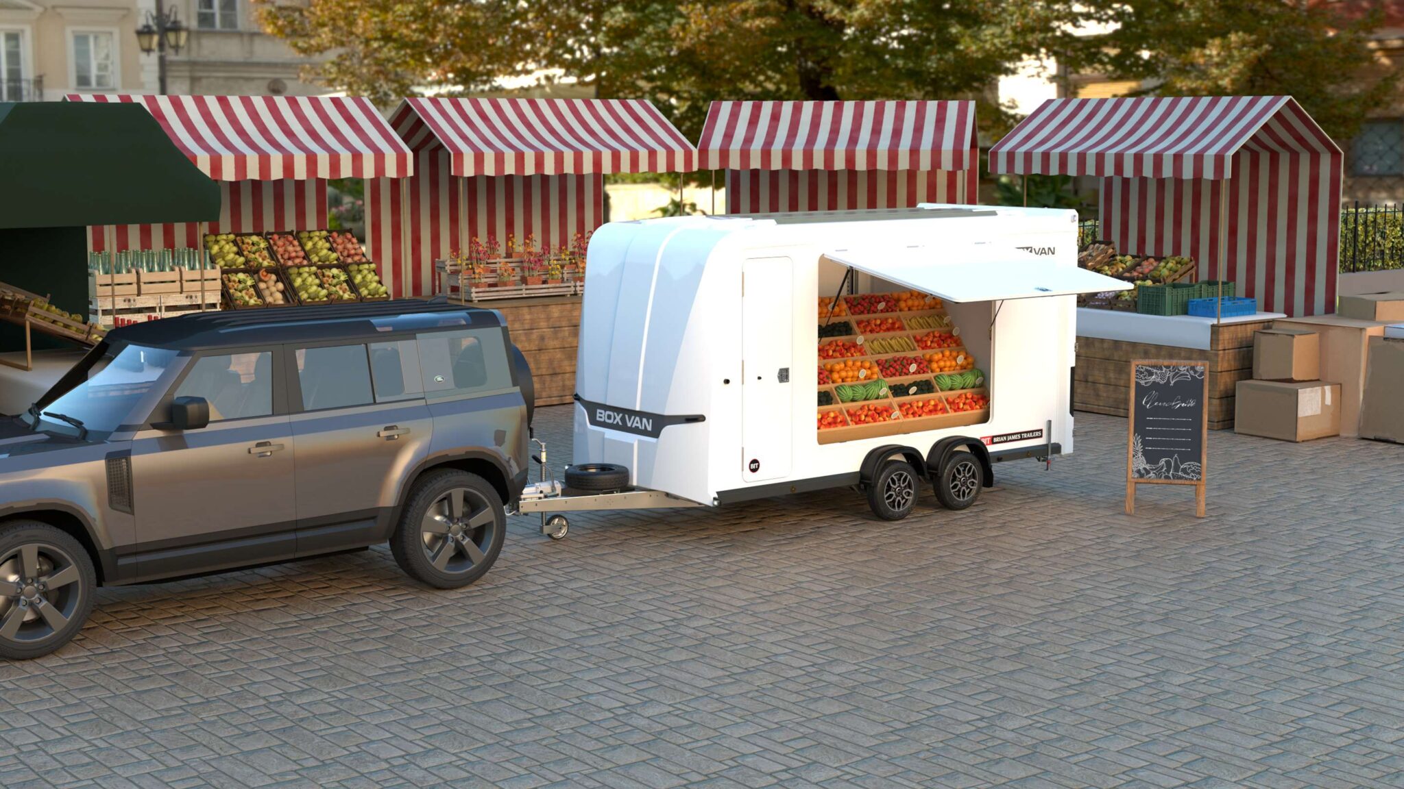 Brian James box van trailer with serving hatch displaying fresh produce at street market, towed by SUV
