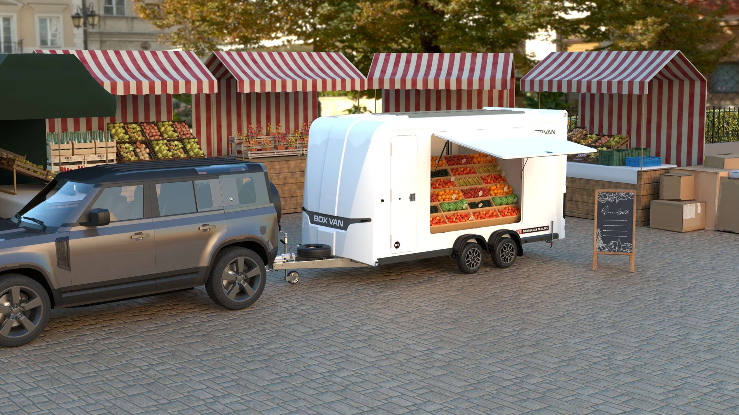 Brian James box van trailer with serving hatch displaying fresh produce at street market, towed by SUV