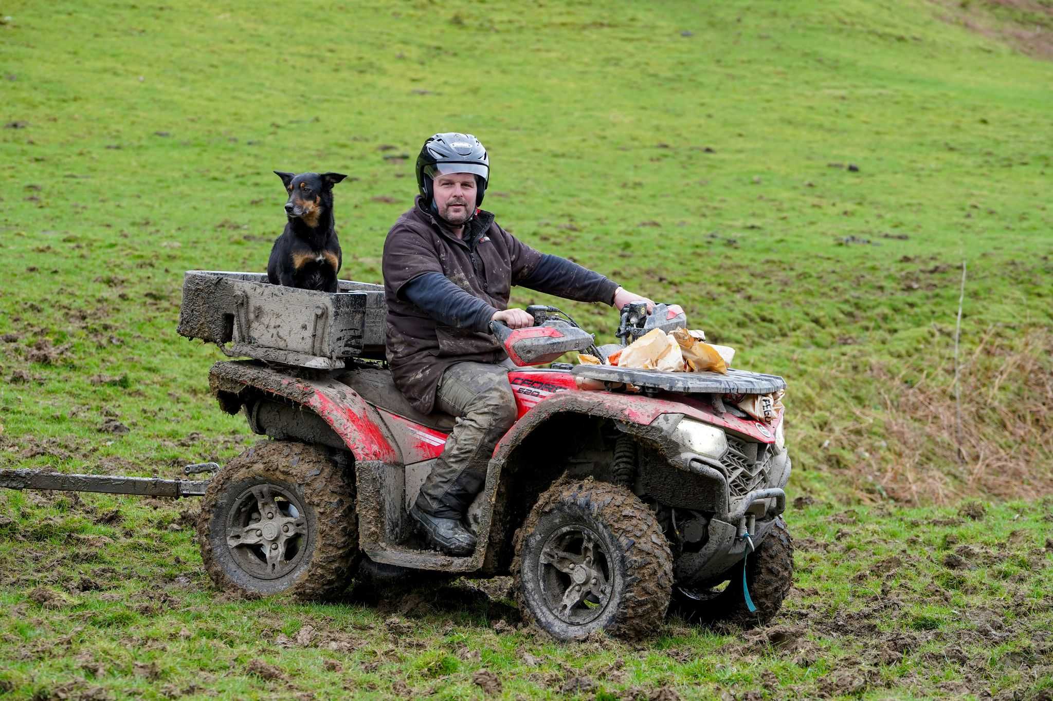 CFMOTO Red ATV offroad quad bike with man riding on farm setting