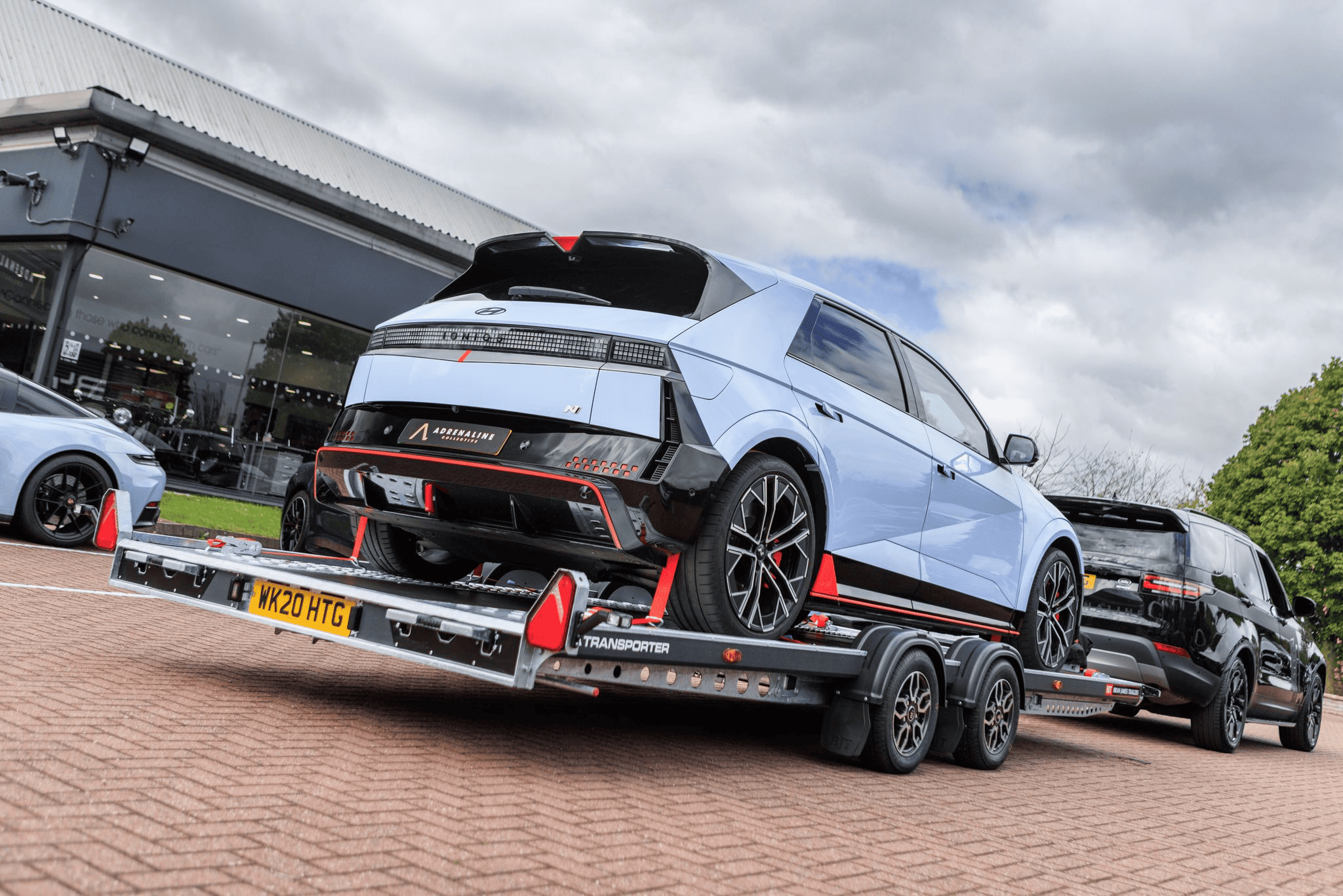Brian James car transporter trailer loading electric hatchback vehicle with straps secured