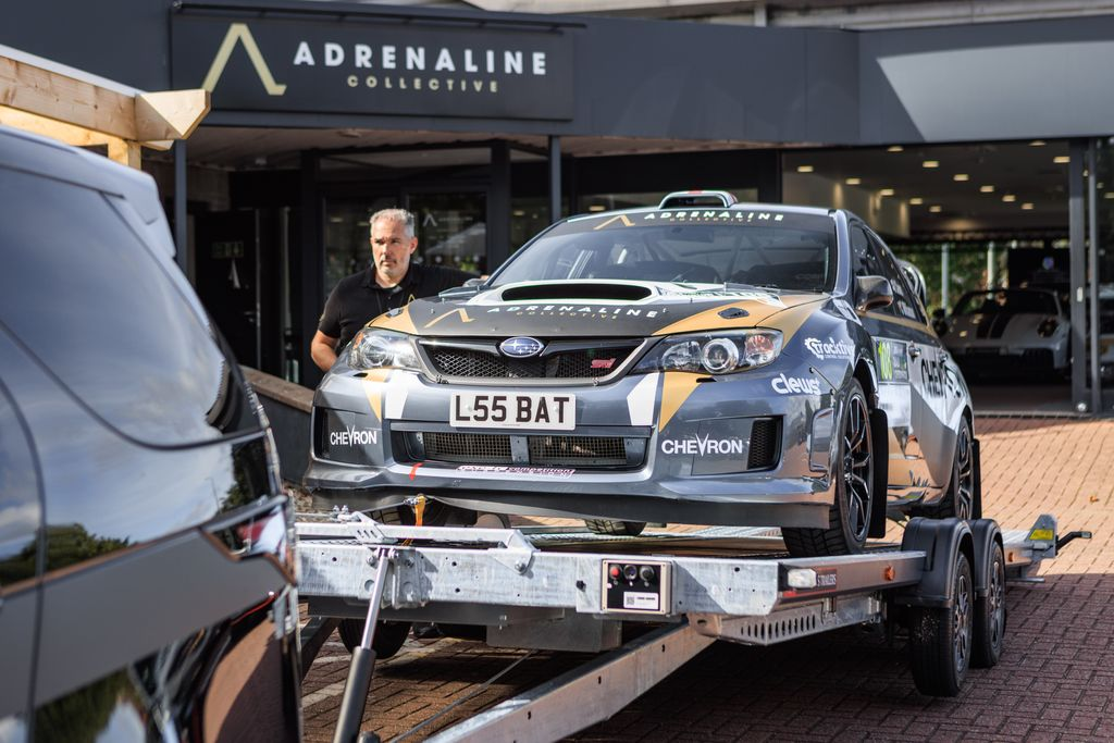 Brian James car transporter trailer loading rally car outside dealership